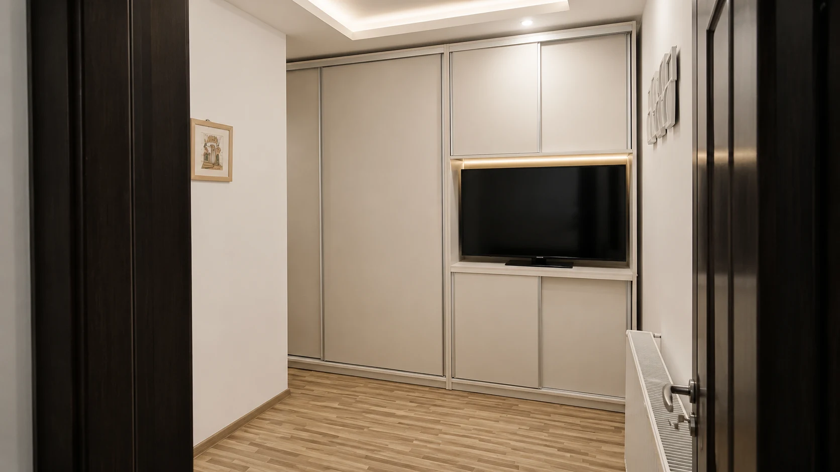 Dulap pe tot peretele cu nișă de televizor integrată, uși glisante și iluminat LED